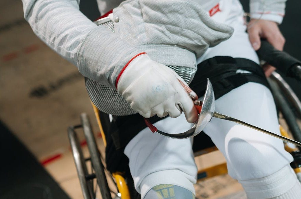 Close-up of a wheelchair fencer gripping a sabre, showcasing focus and determination in sport