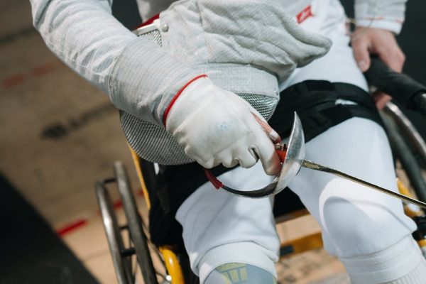 Close-up of a wheelchair fencer gripping a sabre, showcasing focus and determination in sport